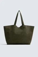 Bolso tipo shopper de gran tamaño confeccionado en piel con acabado de serraje. Cuenta con un compartimento principal abierto, un bolsillo interior con cierre de cremallera y dos asas de mano.