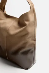 Bolso tipo shopper de piel con acabado en serraje lacado, color marrón degradado. Tiene un compartimento principal con cierre de imán y un bolsillo interior con cierre de cremallera.