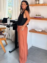 Pantalón tipo palazzo de corte amplio y fluido, confeccionado en lino natural. Presenta cintura elástica con cordón ajustable y bolsillos laterales.