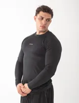 Remera de compresión manga larga color negro, con ajuste al cuerpo y logo de la marca Gains estampado en el pecho. Confeccionada en tejido técnico elástico y transpirable.