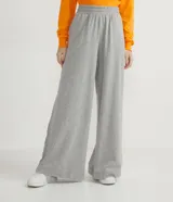Pantalón pantalona de corte amplio, color gris melange, con cintura elástica y rayas laterales en contraste. Confeccionado en tejido de algodón y poliéster.