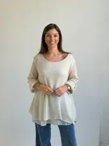 Sweater de punto color beige, de corte amplio y holgado, con escote redondo y mangas largas con presillas para arremangar.