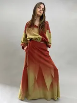 Falda larga de lana con diseño de paneles geométricos y efecto degradado que transiciona de verde esmeralda a tonos amarillentos. Presenta cintura alta, cierre invisible lateral y bolsillos ocultos.