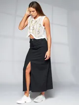 Falda larga negra de denim con abertura frontal y terminación desflecada.