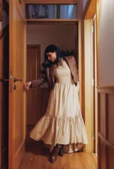 Vestido largo color beige con corte a la cintura, falda amplia con volados y breteles finos.