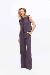 Pantalón de pierna amplia y tiro alto, confeccionado en tejido a rayas con una mezcla de algodón, poliéster y lino. Presenta un diseño de corte sastrero con bolsillos laterales y trabillas para cinturón.