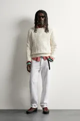 Sweater de punto verde con diseño de trenzas, cuello redondo y manga larga, de corte regular fit y acabados en rib.