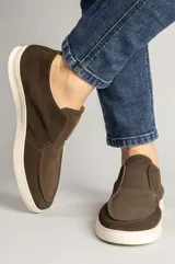 Botín masculino de gamuza color marrón café, de diseño slip-on sin cordones y suela blanca de goma.