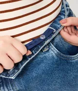 Pantalón de jean azul con lavado medio, corte barrel de piernas amplias, cintura con pasacintos, bolsillos funcionales y pinzas en las piernas.