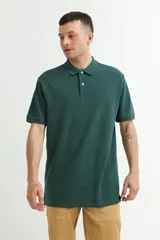 Chomba de piqué verde oscuro con cuello clásico y tapeta de dos botones.