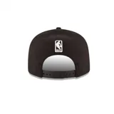 Gorra negra de visera plana marca New Era, con logo bordado de Los Angeles Lakers en el frente y logo de la marca en el lateral.