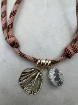 Gargantilla con cordón doble en tonos naranja y gris, con dije de concha dorada y dije de caracol blanco.