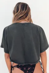 Camiseta gris con efecto lavado, cuello redondo con ribete y mangas cortas tipo capa.