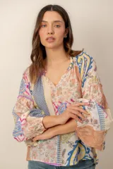 Blusa de manga larga con diseño patchwork multicolor que combina estampados florales, paisley y geométricos, con escote en V y mangas abullonadas.