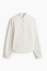 Blusa de mezcla de algodón y viscosa, color blanco con diseño a rayas finas oscuras, cuello alto con volados y mangas largas con puños elastizados con volados.