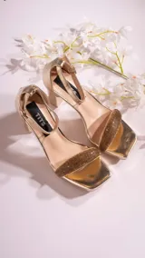 Sandalias negras de cuero sintético, con plataforma y tacón cuadrado. Presentan una tira ancha con strass sobre los dedos y pulsera con hebilla al tobillo.