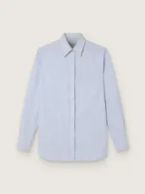 Camisa celeste a rayas verticales blancas, de corte boyfriend, con cuello clásico, cierre frontal oculto, bajo redondeado y parche con logo desmontable en el puño.