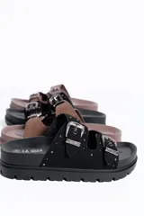 Sandalia negra con plataforma y suela track. Posee dos tiras anchas en el empeine con hebillas metálicas plateadas de estilo western, detalles de tachas y plantillas anatómicas.