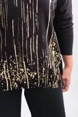 Sweater de punto negro con escote en V y mangas largas, presenta un estampado abstracto de líneas verticales y salpicaduras en color dorado.