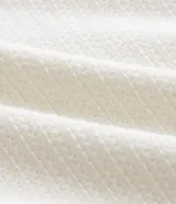 Remera de manga corta con cuello redondo, confeccionada en tejido texturizado de mezcla de algodón y poliéster en color blanco.