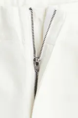 Pantalón de jean blanco de corte wide leg y tiro alto, con diseño de pierna amplia, bolsillos laterales al bies y raya marcada en el frente.