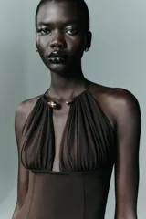 Body entallado de poliamida color marrón, con escote profundo y cuello metálico tipo choker integrado. Presenta un diseño sin mangas con frunces en el busto.