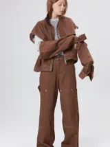 Campera de denim a rayas verticales con cuello de pana en color bordó. Presenta cierre frontal, mangas desmontables con cierre en los hombros, canesú en el pecho y bolsillos de parche cuadrados.