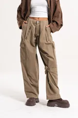 Pantalón cargo de tiro medio-alto en color verde oliva, con diseño holgado, múltiples cierres decorativos y funcionales, y bolsillos laterales.