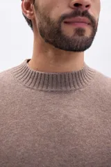 Buzo de tejido de punto con cuello redondo, mangas largas y puños acanalados, en color taupe.