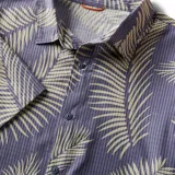 Camisa de manga corta azul con estampado de hojas color crema.