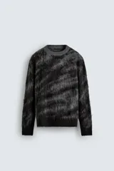 Jersey de corte relajado con cuello redondo y manga larga, confeccionado en tejido cepillado con patrón jacquard en tonos oscuros y acabados en rib.