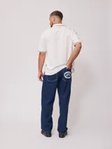 Remera polo blanca de corte regular, con cuello y mangas con ribete a cuadros en contraste. Presenta un pequeño logo bordado en el pecho.