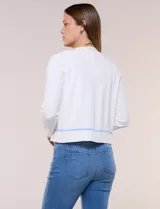 Cardigan de punto fino color blanco, con detalles de bordados florales en tono celeste, mangas largas y frente abierto con ribetes celestes.