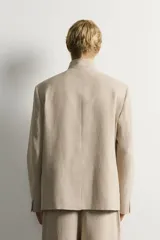 Blazer de corte relaxed fit confeccionado en tejido de lino y algodón de origen italiano. Presenta cuello mao, cierre cruzado con botones, bolsillos de vivo en la cadera y manga larga.