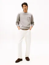 Buzo de cuello redondo Tommy Hilfiger en color gris melange, con diseño de logo y escudo bordados en el pecho. Presenta puños y ruedo acanalados.