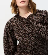 Cardigan de punto con estampado animal print, cuello redondo y cierre frontal con botones. Presenta mangas largas abullonadas con puños ajustados y un corte corto.