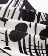 Pareo de playa rectangular confeccionado en viscosa liviana de color blanco, con estampado de caracolas marinas y detalles gráficos en negro en los bordes.