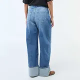 Jean de corte regular y cintura alta, confeccionado en denim azul con lavado stonewash. Presenta un diseño de pierna recta con un dobladillo ancho en la parte inferior.