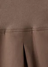 Pantalón balloon de tiro alto color marrón, confeccionado en algodón, con cintura ajustable con elástico, pinzas en la parte delantera, bolsillos laterales y bajos fruncidos con elástico.