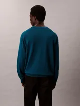 Sweater Calvin Klein de corte relajado, color azul oscuro, con cuello redondo y el logotipo CK bordado en contraste en el pecho. Presenta puños, cuello y dobladillo acanalados.
