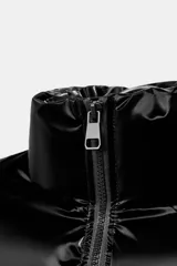 Anorak acolchado de efecto brillante con tejido cortavientos y repelente al agua. Presenta cuello subido, cierre frontal con cremallera, bolsillos delanteros con forro polar y cierre de cremallera, y mangas largas con puños elásticos. El bajo es ajustable con cordones elásticos laterales.