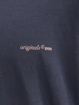 Remera oversize gris oscuro de corte holgado, con cuello redondo, mangas cortas y pequeño texto estampado en el pecho.
