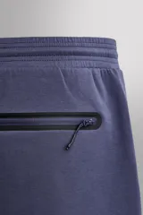 Pantalón jogger relaxed fit Zara Athleticz de tejido técnico compacto elástico con mezcla de algodón. Presenta cintura elástica ajustable con cordón, bolsillos laterales en la cadera, bolsillo trasero con cierre de cremallera, bajo ajustable con elástico y detalle de logo estampado en la pernera.