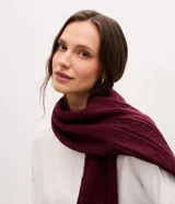 Bufanda de punto color bordó con diseño de textura trenzada y terminaciones acanaladas.