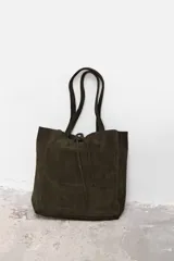 Bolso tipo tote de gamuza en color verde oscuro, con diseño minimalista, doble asa de hombro y cierre mediante cordón ajustable en la parte superior.