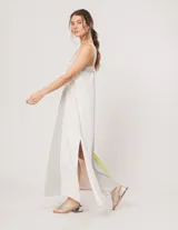 Vestido largo de lino color blanco, gris y amarillo, con breteles anchos, escote recto, elástico en la espalda y tajos laterales.