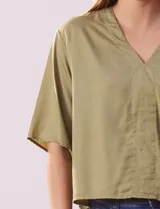 Blusa blanca de lyocell con escote en V y mangas cortas.