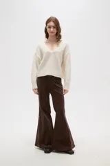 Sweater negro de punto con escote en V profundo y detalle de encaje en el borde del cuello. Presenta mangas largas con puños acanalados y un corte holgado.