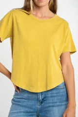 Remera oversize de algodón lavado color mostaza, de manga corta y cuello redondo. Presenta un pequeño bordado en forma de estrella en la parte inferior.