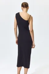 Vestido midi negro confeccionado en punto de crepé, de corte ajustado con escote asimétrico, un bretel fino y un hombro drapeado. Presenta frunces laterales que generan un efecto drapeado en la cintura y largo hasta la rodilla.